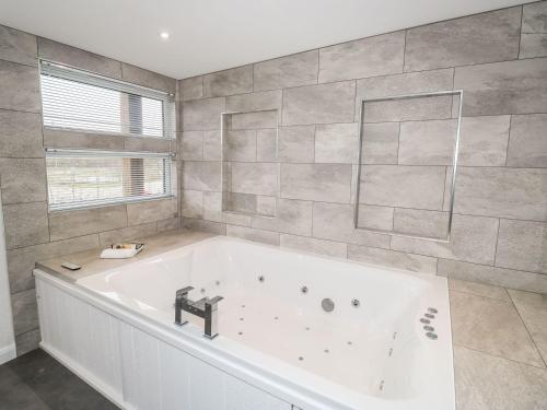 a large white bath tub in a bathroom at 1 Southern Place in Liskeard