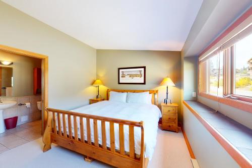 een slaapkamer met een bed, een wastafel en een raam bij Blacksmith Lodge 2 in Big White