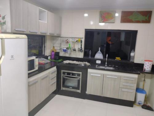 a kitchen with a black counter top and a refrigerator at Hospedagem da Val in Angra dos Reis