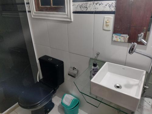 a bathroom with a toilet and a sink at Hospedagem da Val in Angra dos Reis