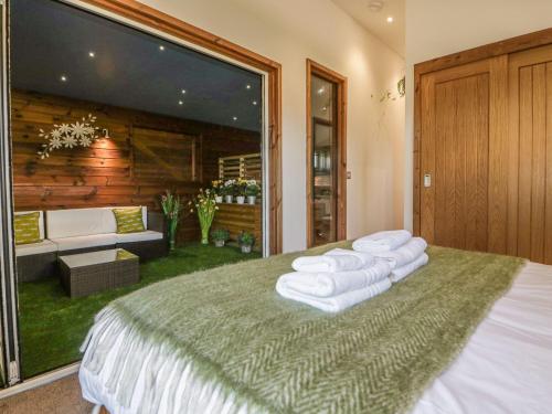 a bedroom with a large bed with towels on it at 9 Meadow Retreat in Liskeard