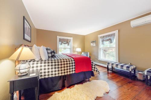 a bedroom with a bed and two windows at Pied-A-Terre in Kennebunkport