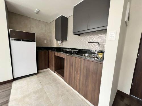 a kitchen with a white refrigerator and wooden cabinets at Apartamento Nuevo con Hermosa Vista, Ubicación Perfecta in La Paz