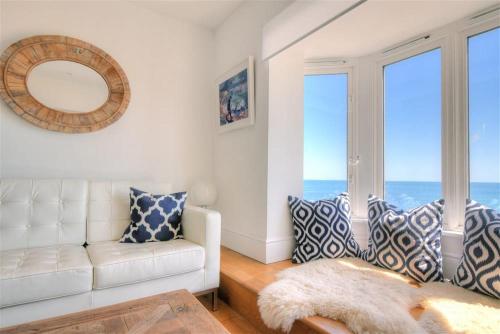 a living room with a white couch and large windows at Seahorse in Lyme Regis