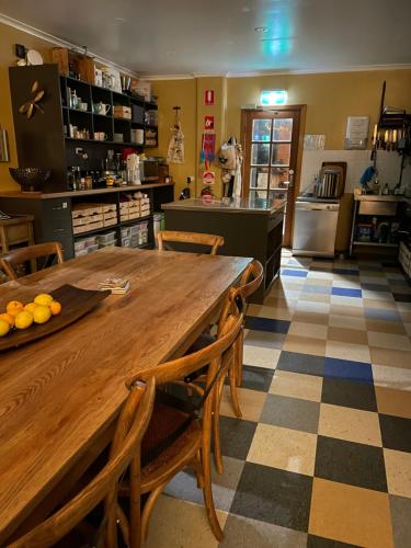 een keuken met een grote houten tafel en stoelen bij KI Dragonfly Guesthouse in Kingscote