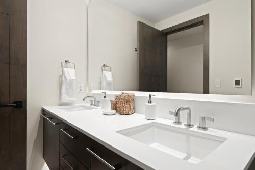 a bathroom with two sinks and a large mirror at Altus #206 in Vail