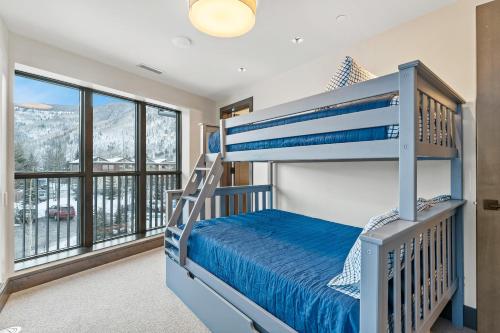 a bedroom with a bunk bed and a balcony at Altus #206 in Vail