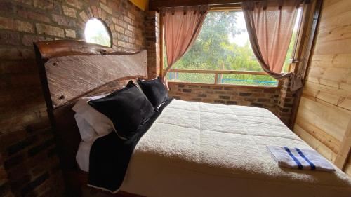 a bedroom with a bed with a large window at Chalet Amadeus Guatavita in Guatavita