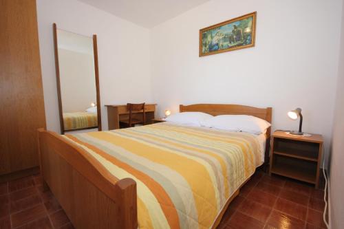 Un dormitorio con una cama grande y un espejo. en Holiday house with WiFi Ustrine, Cres - 8037, en Ustrine