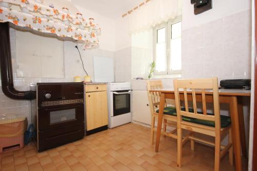 y cocina con mesa, sillas y fogones. en Holiday house with WiFi Ustrine, Cres - 8037, en Ustrine