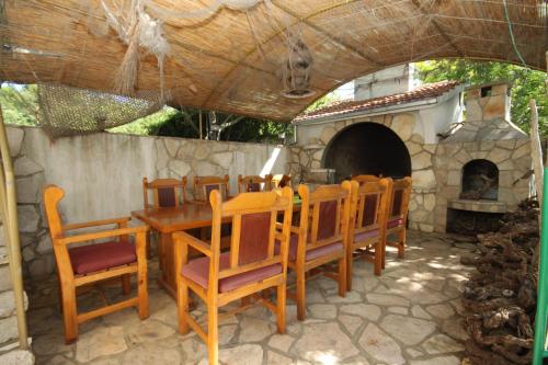 un tavolo e sedie in legno e un forno in pietra di Apartment Stari Grad 8780b a Stari Grad (Cittavecchia)