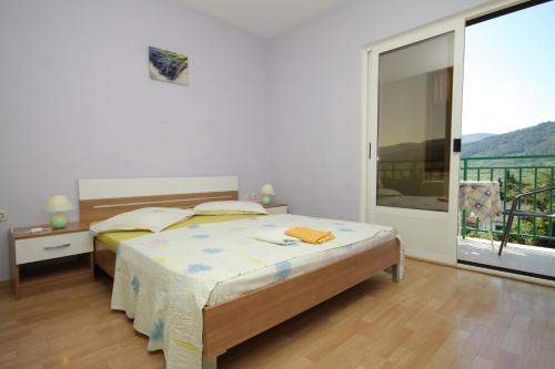 una camera con un letto e una grande finestra di Apartment Stari Grad 8780b a Stari Grad (Cittavecchia)