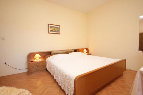 a bedroom with a bed and a night stand with two lamps at Apartments and rooms with parking space Srebreno, Dubrovnik - 8959 in Mlini