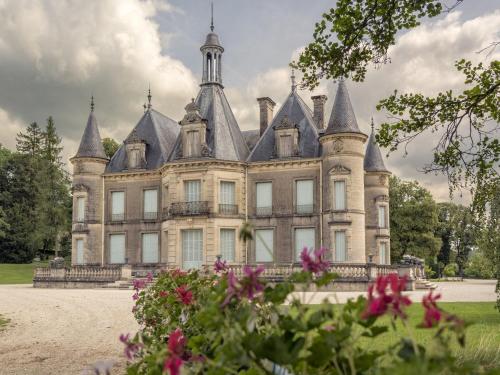 an old castle with a bunch of flowers in front of it at Gîte pour 12 face au château de Thillombois avec jardin, cheminée et équipements PMR - FR-1-585-38 in Thillombois