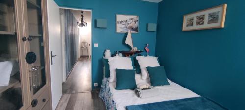 a blue bedroom with a bed with white pillows at 2 chambres côté plage in Hyères