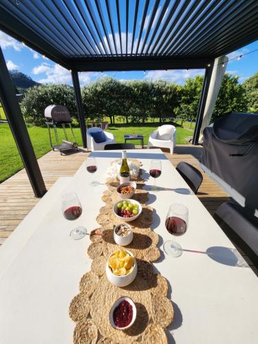 uma mesa com pratos de comida e copos de vinho em Hahei Magic em Hahei