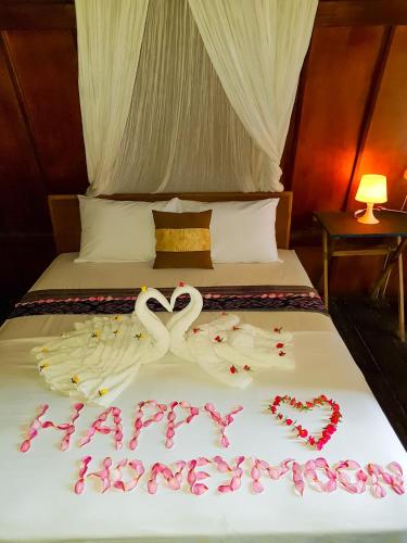 a bed with two swans made to look like hearts at Leaf Coco Bungalow in Gili Air