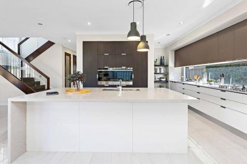 eine Küche mit einer großen weißen Insel in der Mitte in der Unterkunft Luxury Brand New Home in Shellharbour
