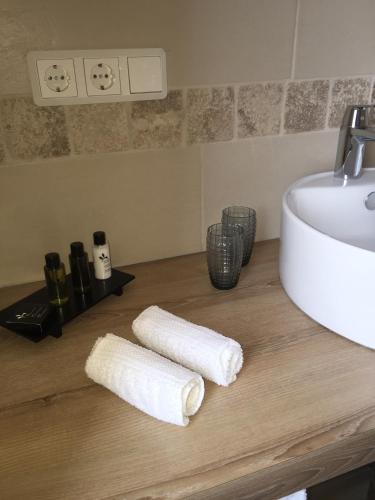 a bathroom with two rolled towels on a counter next to a sink at Hotel Achilles in Kirkel