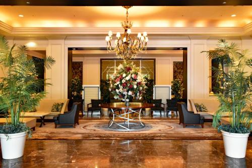 eine Lobby mit einem Tisch und einem großen Blumenarrangement in der Unterkunft Okura Chiba Hotel in Chiba