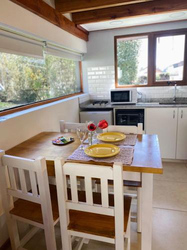 a kitchen with a wooden table with two chairs and a tableablish at La Tante in San Carlos de Bariloche