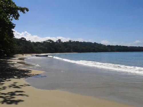 a beach with waves coming in from the ocean at Cabinas Manzanillo Caribe in Manzanillo