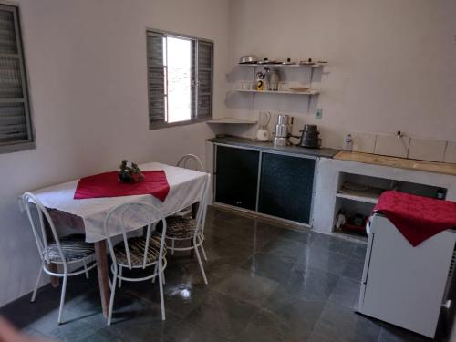 a kitchen with a table and chairs in a room at Casa Cogumelo Azul in São Thomé das Letras