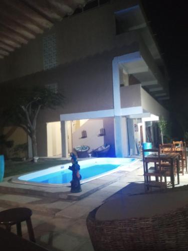 a fire hydrant in front of a pool at night at Pousada paraiso das dunas in Cumbuco