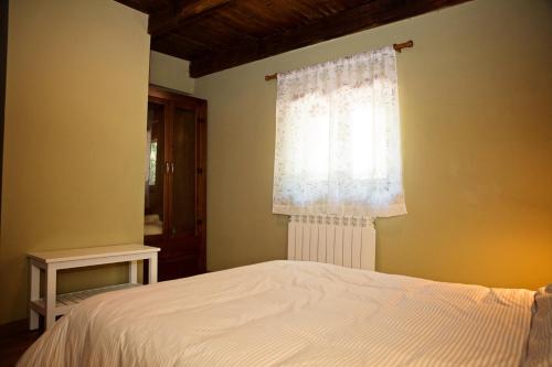 a bedroom with a white bed and a window at Apartamentos turísticos LAS CARBALLEDAS in Rabanal del Camino