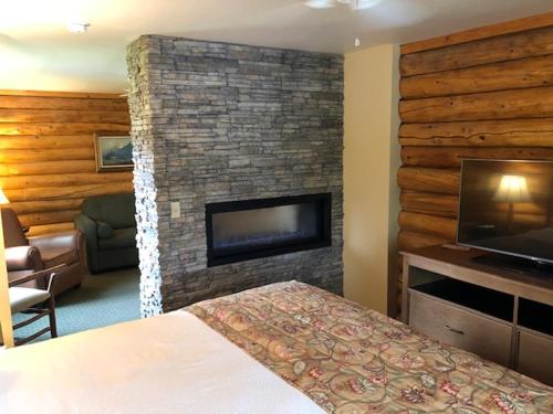 a living room with a fireplace and a bed at Pike's Waterfront Lodge in Fairbanks