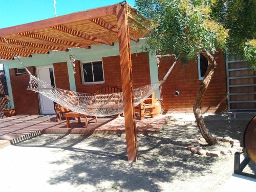 a hammock in front of a house at Antü in Puerto Pirámides