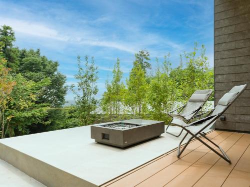 a patio with a fire pit and two chairs on a deck at Rakuten STAY VILLA Aso Kurokawa -102 1LDK Capacity of 6 persons in Minamioguni