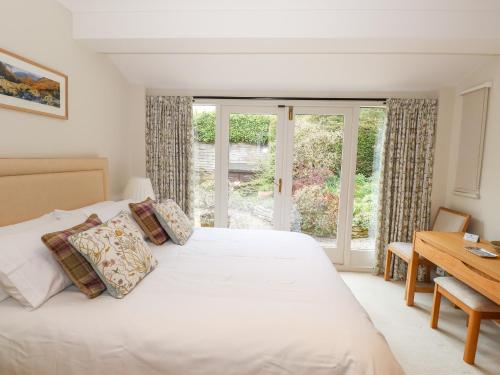 a bedroom with a bed and a desk and a window at Edencroft in Penrith