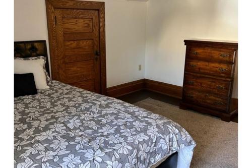 1 dormitorio con cama y tocador de madera en Grand Old White Artist's Loft en Charleston