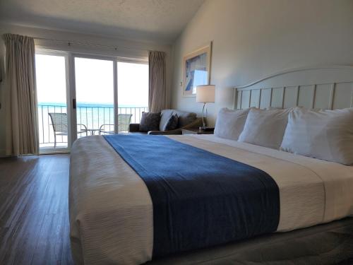 a hotel room with a large bed and a balcony at Pointes North Beachfront Hotel - 2 Person Spa Tub Studios in Traverse City