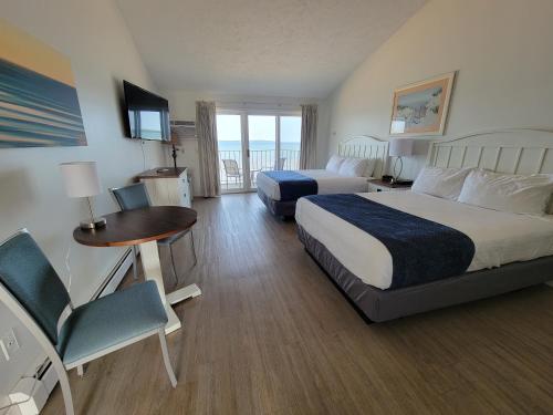 a hotel room with two beds and a table and chairs at Pointes North Beachfront Resort Hotel in Traverse City