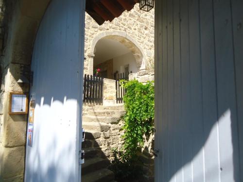 einen Eingang zu einem Gebäude mit einer Treppe und einem Torbogen in der Unterkunft Le Mas des Monèdes in Saint-Paul-le-Jeune