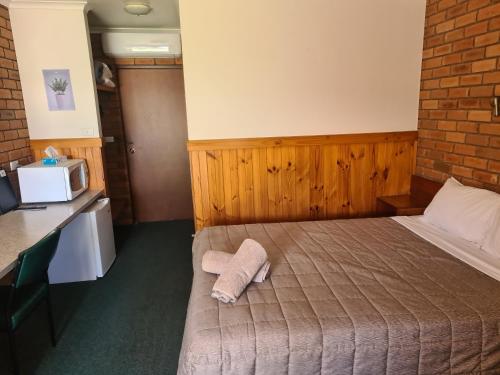 a hotel room with a bed with a towel on it at Regency Court Motel in Cobram
