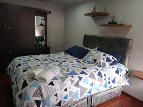 sypialnia z łóżkiem z niebiesko-białą kołdrą w obiekcie Apartamento Amoblado en Facatativá w mieście Facatativa