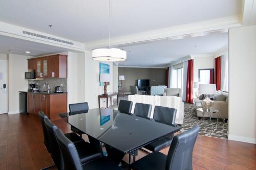 a dining room and living room with a table and chairs at Chateau Lacombe Hotel in Edmonton