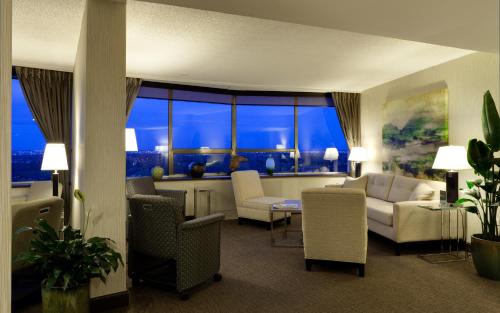 a living room with white furniture and a large window at Chateau Lacombe Hotel in Edmonton
