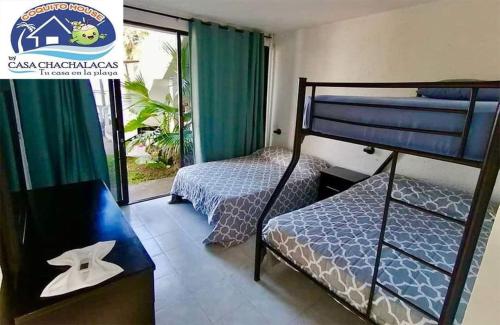a bedroom with two bunk beds and a balcony at COQUITO HOUSE CHACHALACAS in Chachalacas