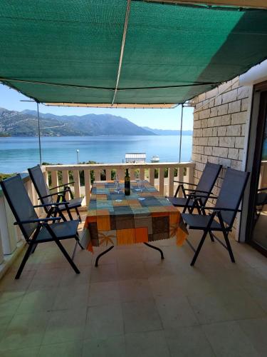 a table and chairs on a patio with a view of the water at Apartment Ante in Račišće