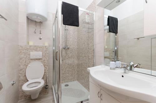a bathroom with a toilet and a sink and a shower at Apartment Tarle in Vodice