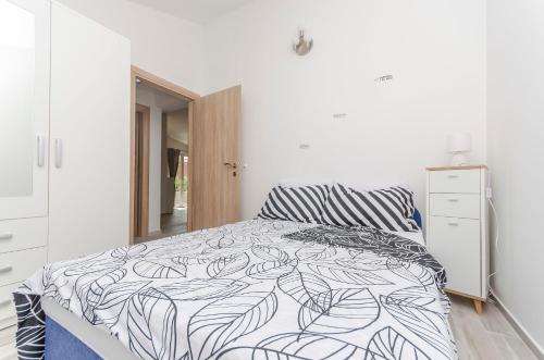 a bedroom with a bed with a black and white comforter at Apartment Tarle in Vodice