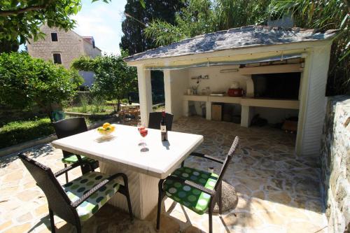 a table and chairs sitting under a shed at Apartment and Room Lada in Sumartin