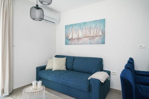 a blue couch in a living room with a painting at House Luxury Konforta in Brodarica
