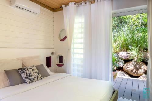 una camera con un letto e una grande finestra di Magnifique et spacieux T2 proche de la plage - La Kiss House a Deshaies