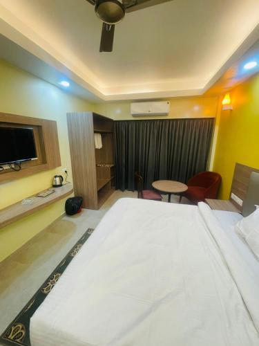 a hotel room with a large bed and a table at Royal Beach International in Puri