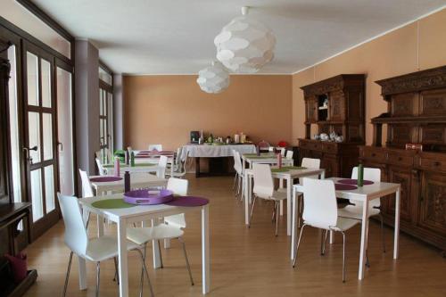 a dining room with white tables and white chairs at Tenuta Roletto in Cuceglio